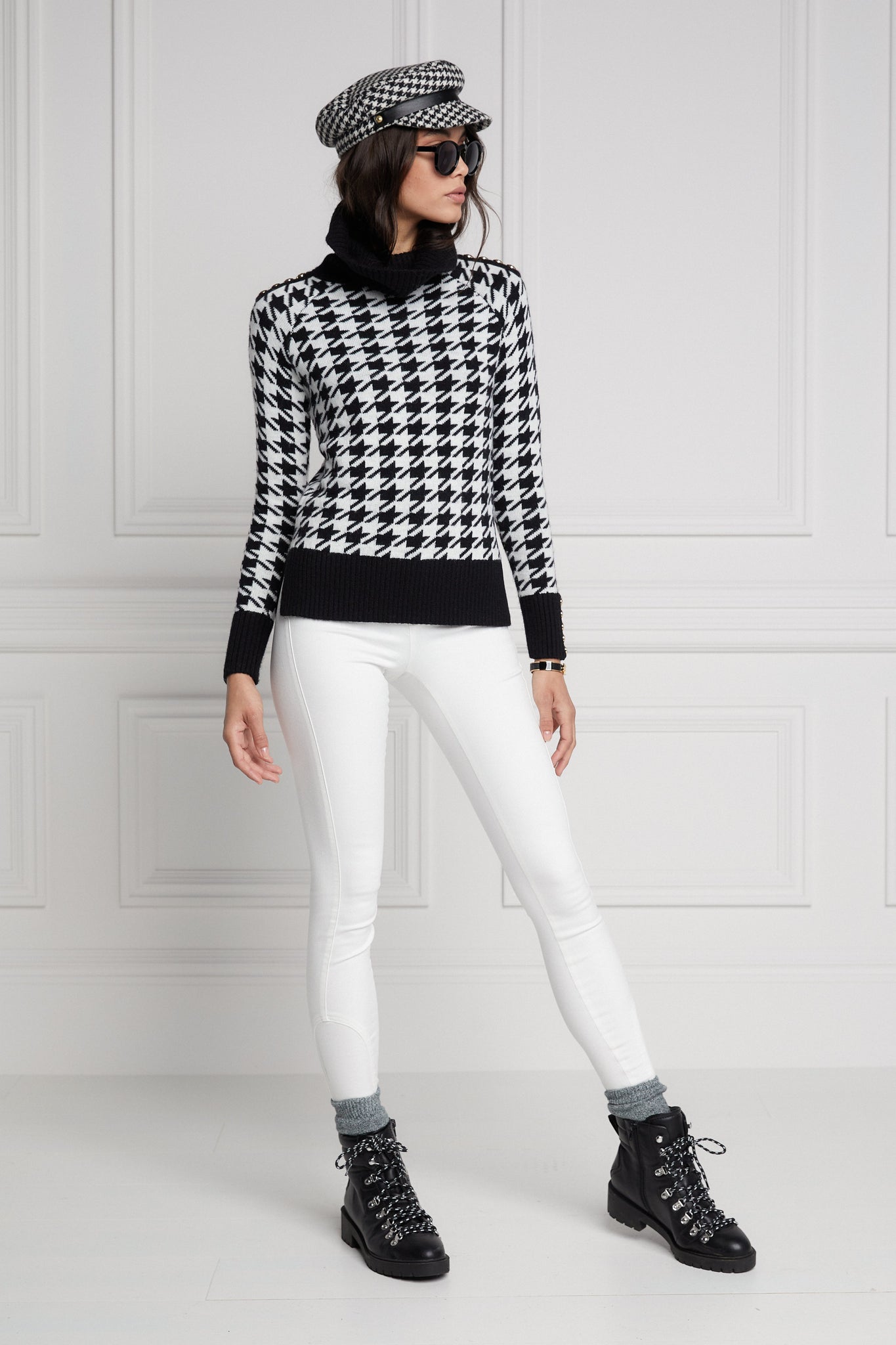 a classic black and white houndstooth jumper with contrast black cuffs, roll neck and split ribbed hem with gold button detail on the cuffs and collar