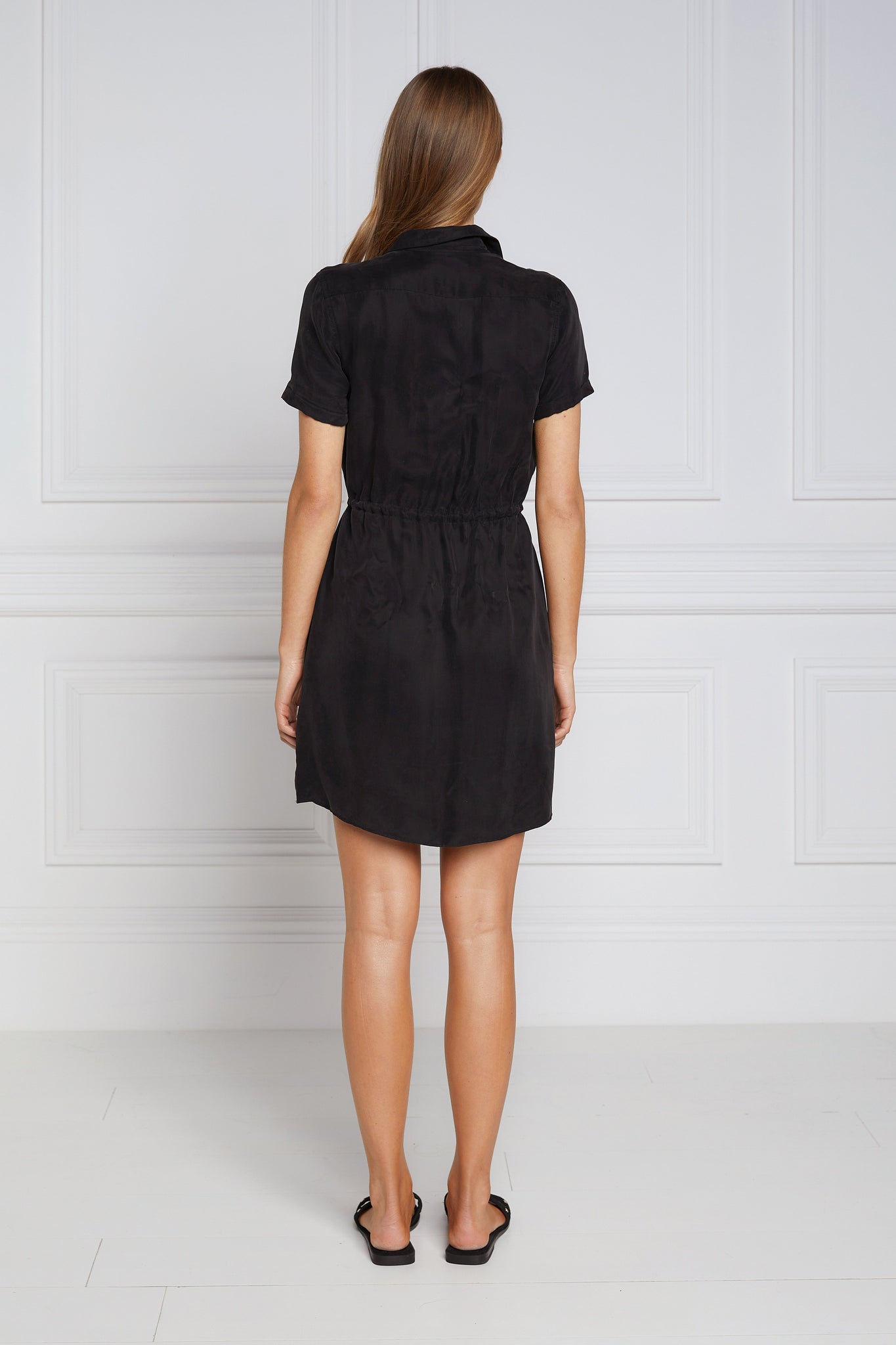 back shot of womens black military mini shirt dress with drawcord tie around the waist and gold buttons down the front