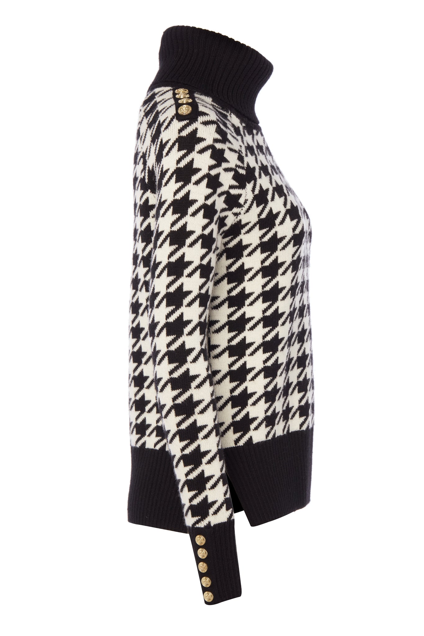 side of a classic black and white houndstooth jumper with contrast black cuffs, roll neck and split ribbed hem with gold button detail on the cuffs and collar