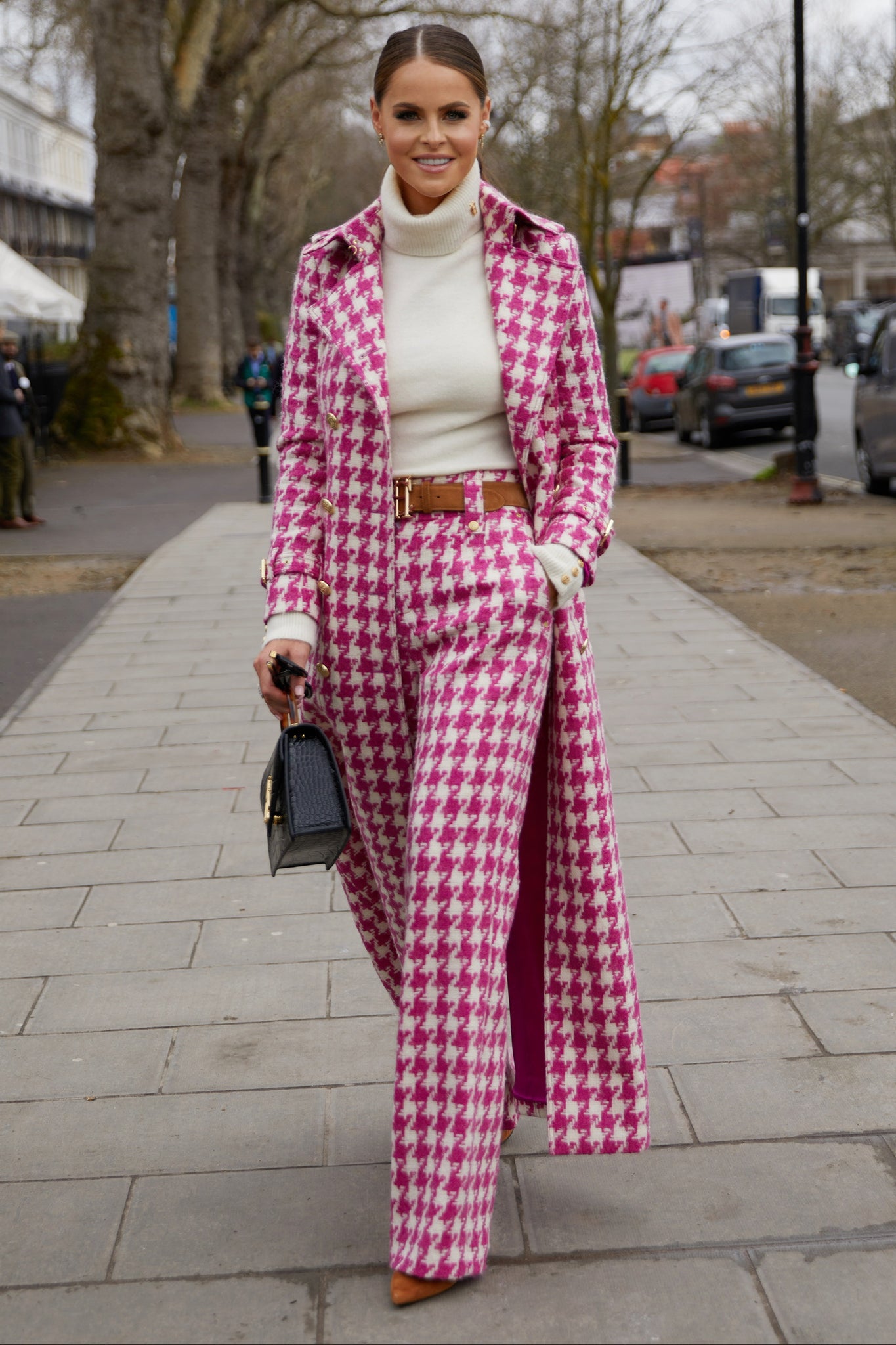 Women's hot pink houndstooth wool high waisted straight trousers with white roll neck top, tan suede belt and hot pink houndstooth trench coat