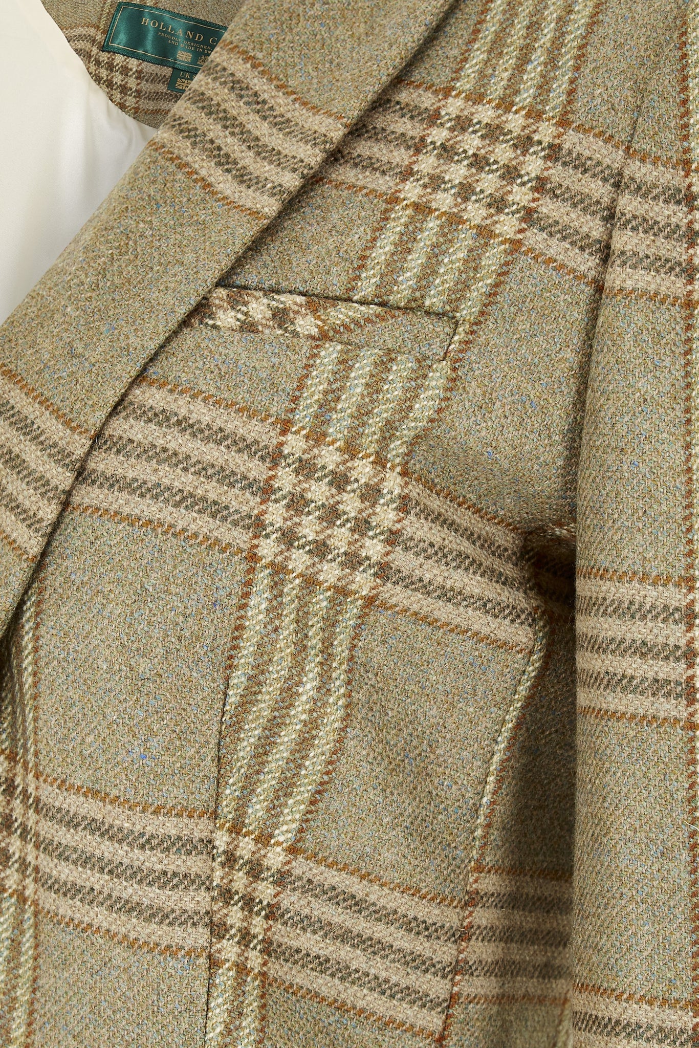 pocket detail of green tweed womens coat with gold hardware and tan suede detailing