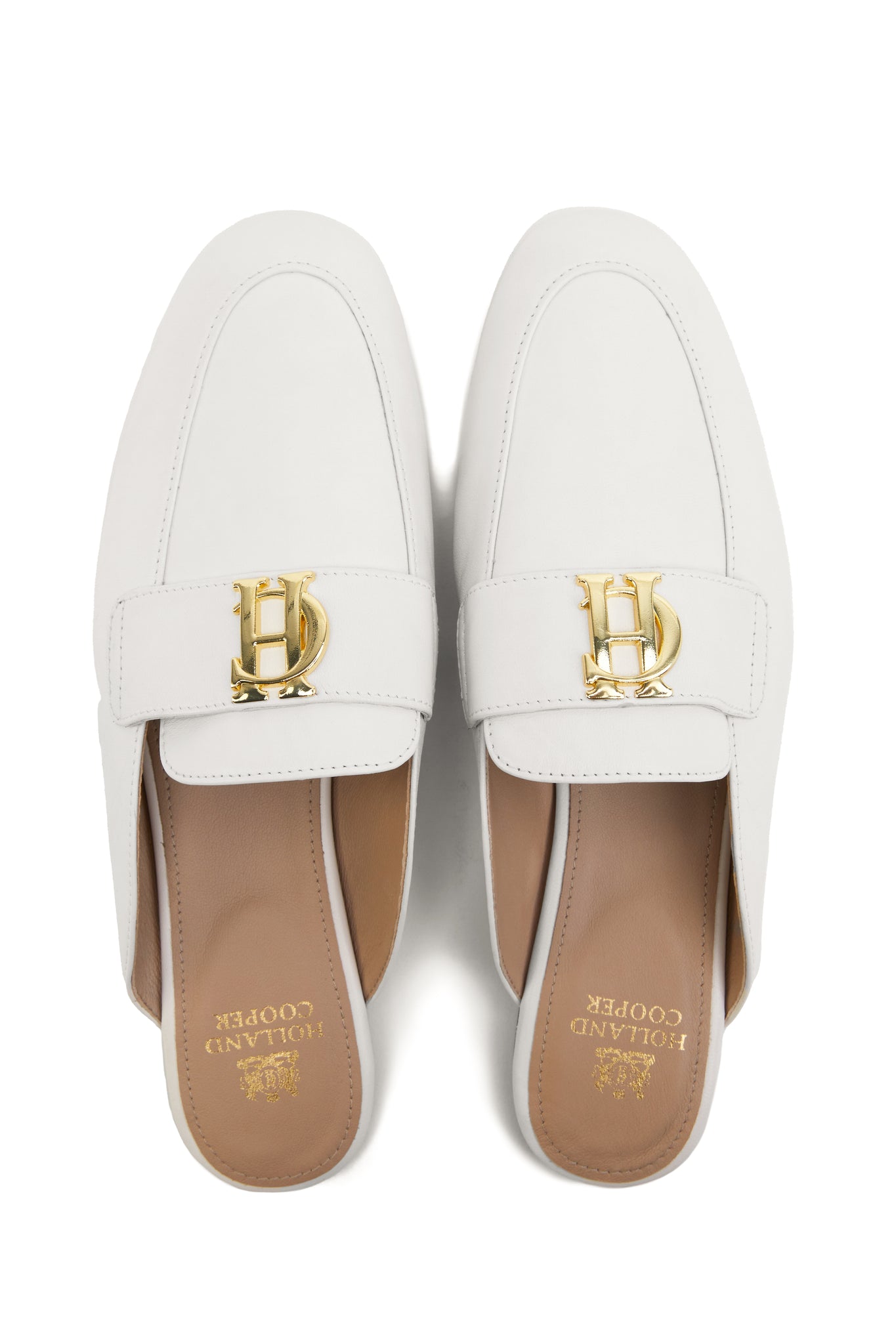 white leather backless loafers with a slightly pointed toe and gold hardware to the top and gold foil branding on inner sole