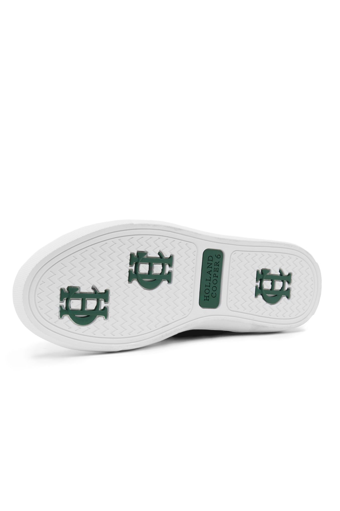 White leather sole of trainer with dark green branding