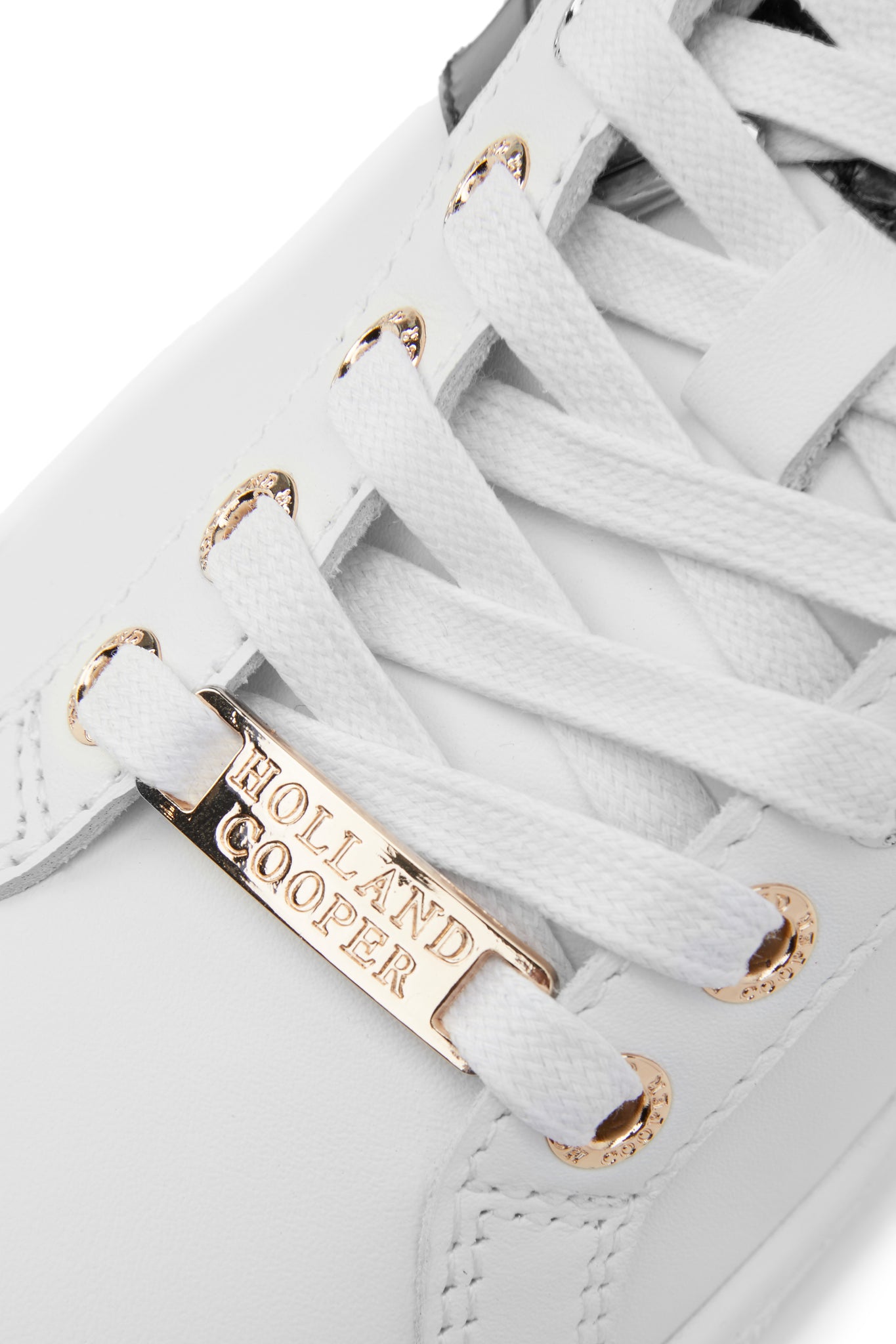 Birds eye view of the gold details on the white laces of the trainer