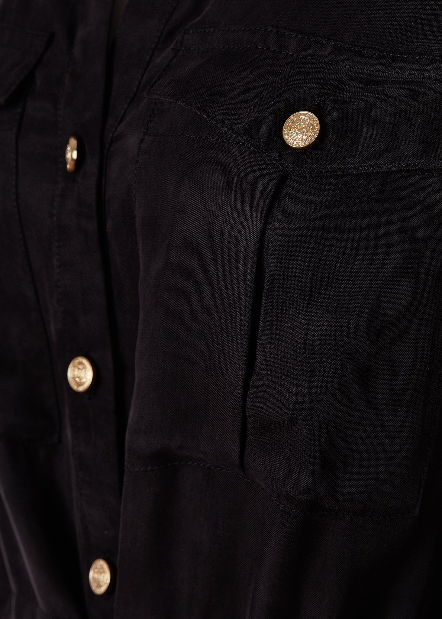 detail shot of gold buttons on womens black military mini shirt dress with drawcord tie around the waist