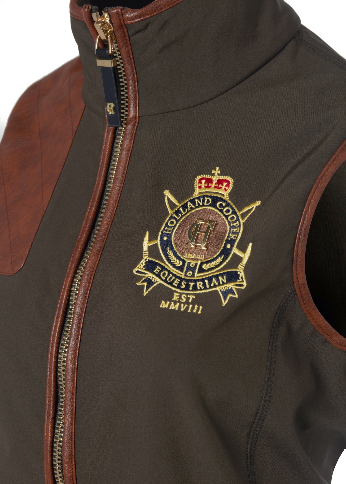 detail shot of the embroidered logo on the womens khaki gilet with dark brown leather seams along the arm holes pockets and down the zip with a gun patch on the shoulder