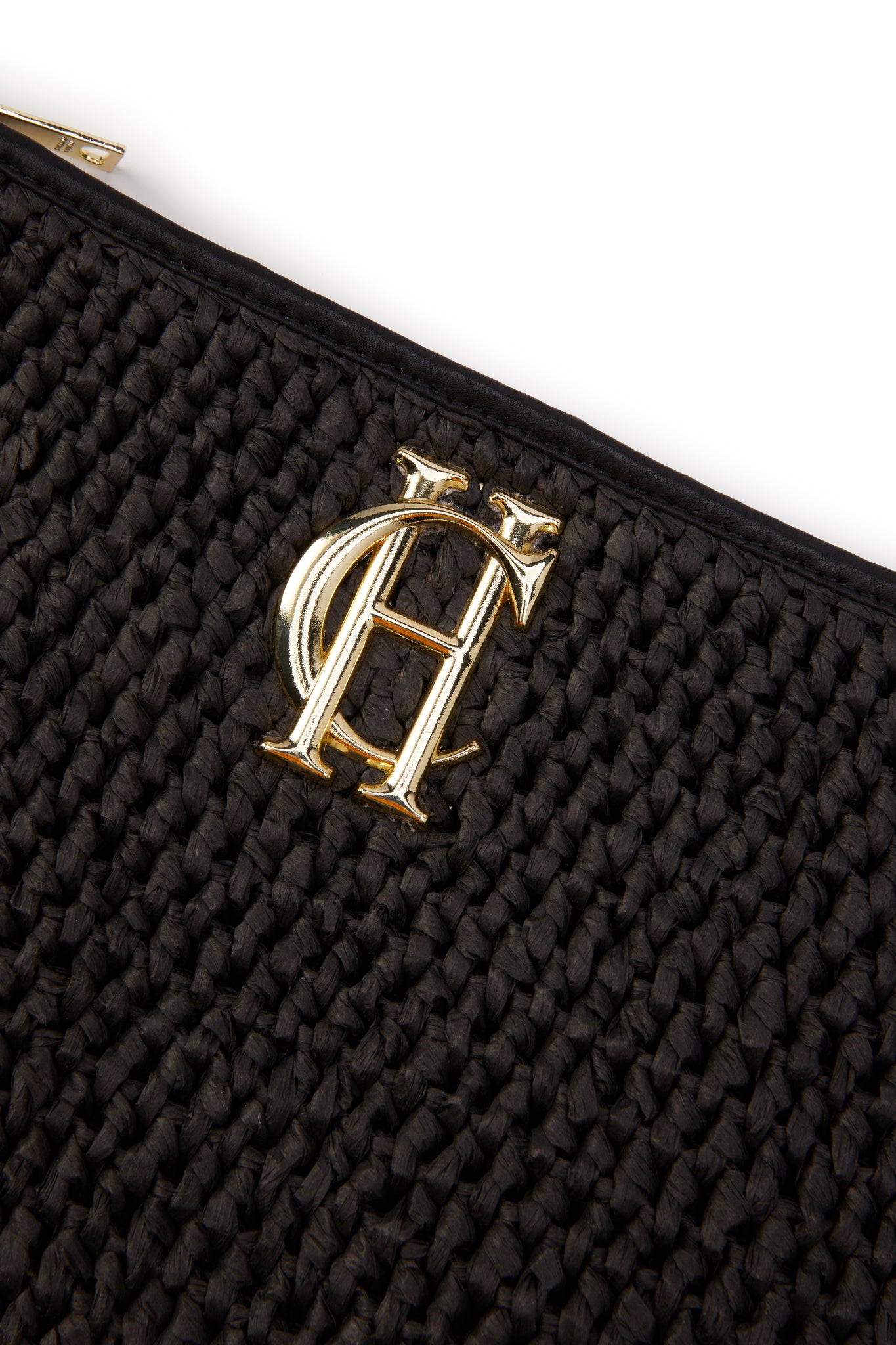 detail shot of gold hardware on black raffia bag