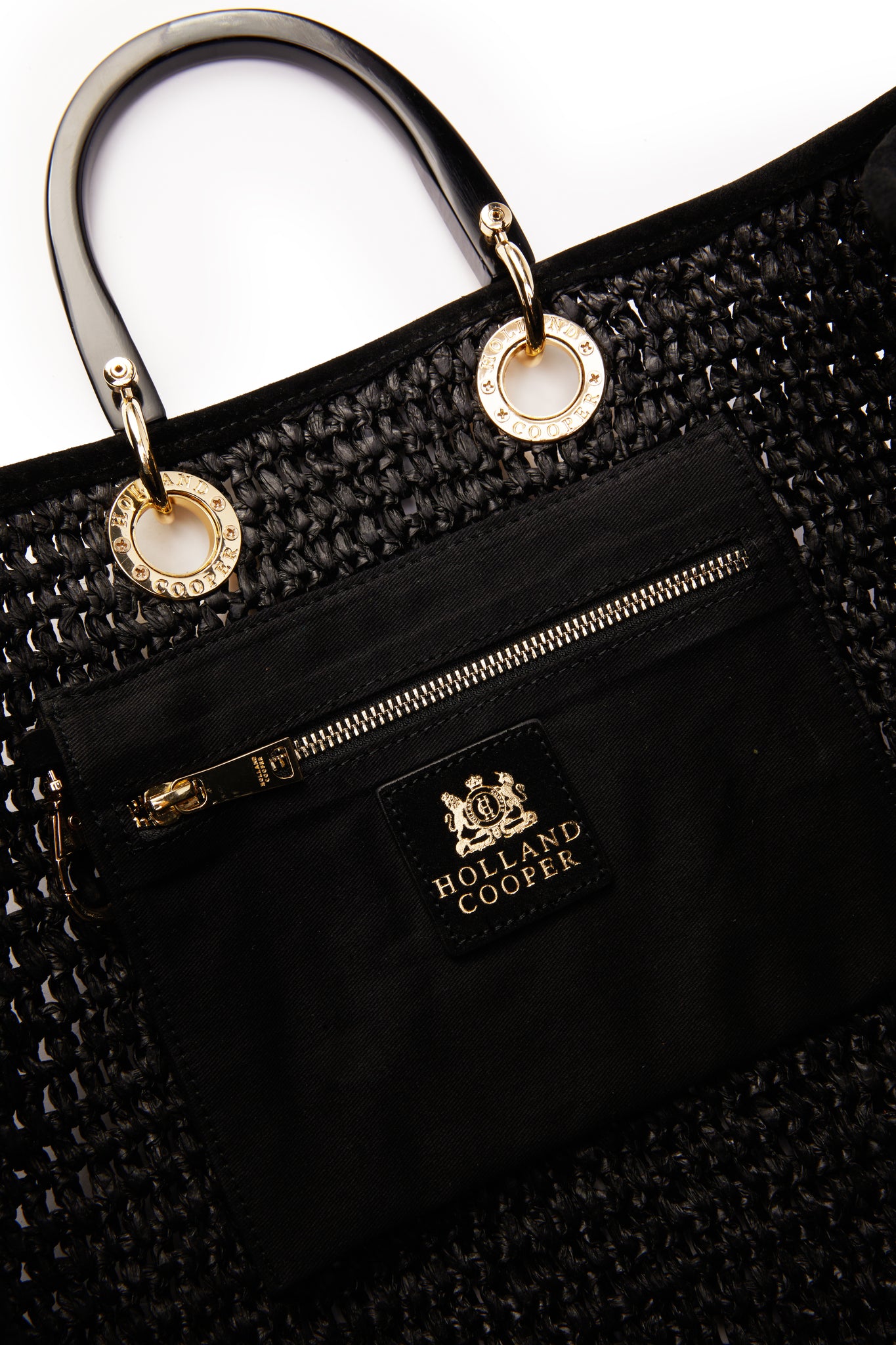 inside black zip up pouch of womens black raffia tote bag 