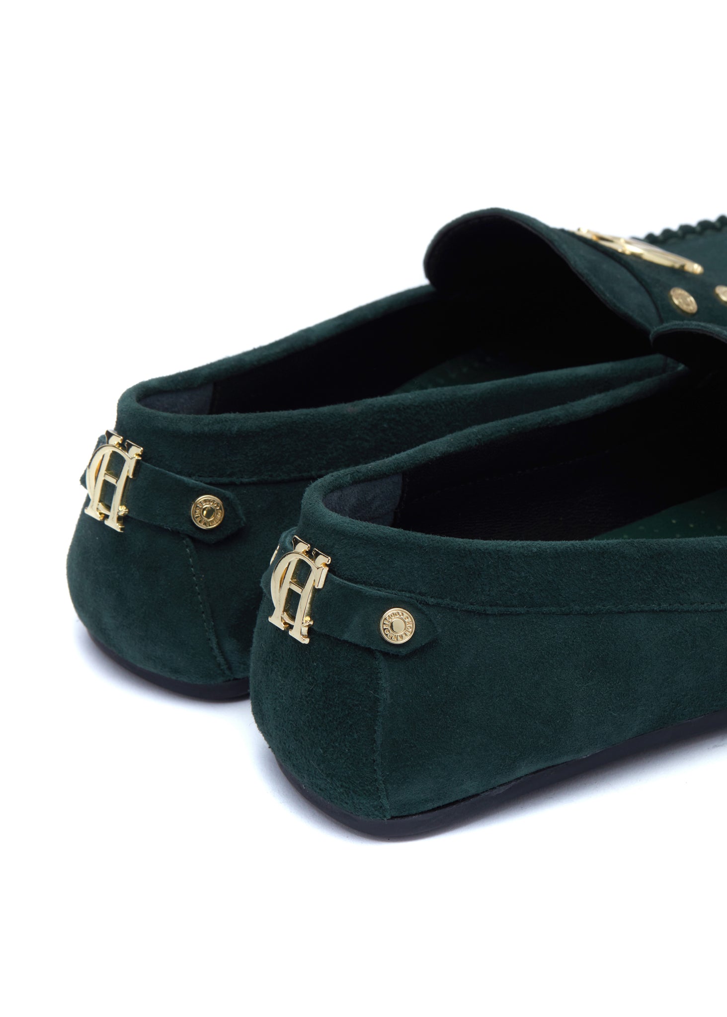 Back of classic emerald green suede loafers with a leather sole and top stitching details and gold hardware with a dark green inner sole