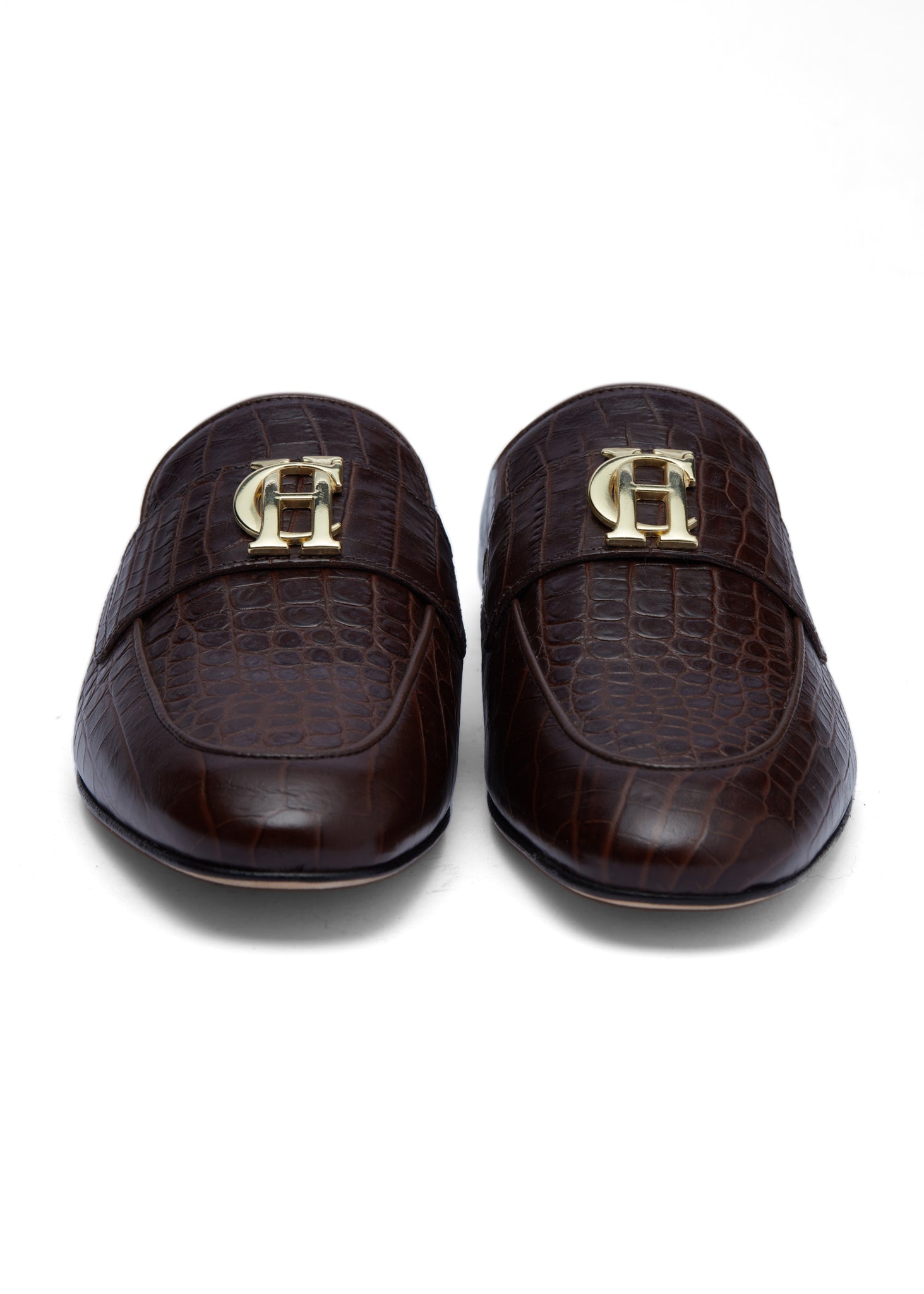 Front shot of Brown croc embossed leather backless loafers with a slightly pointed toe and gold hardware to the top 