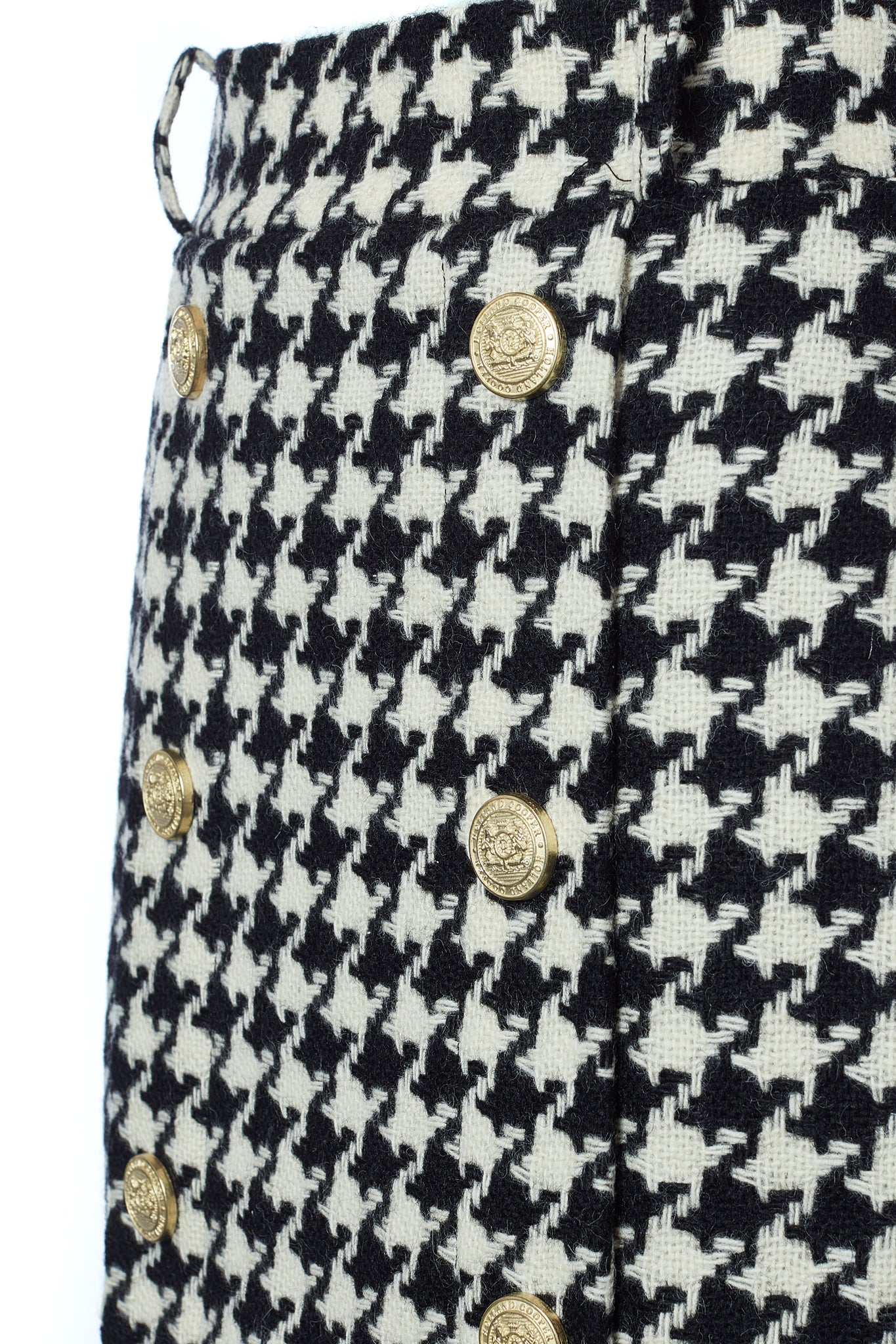 gold rivet front detail of womens black and white large scale houndstooth wool pencil mini skirt with concealed zip fastening on centre back and gold rivets down front