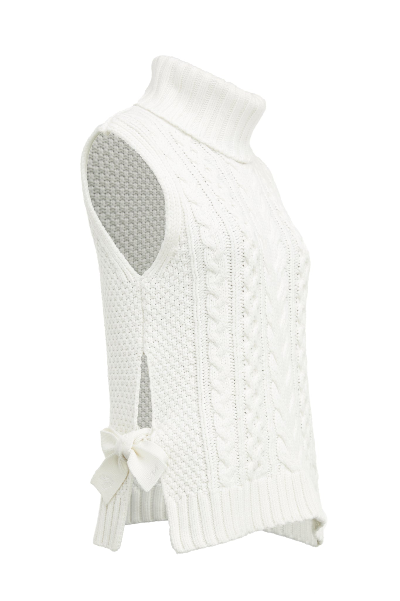 Sleeveless white chunky knit cable jumper with a roll neck and ties at each side 