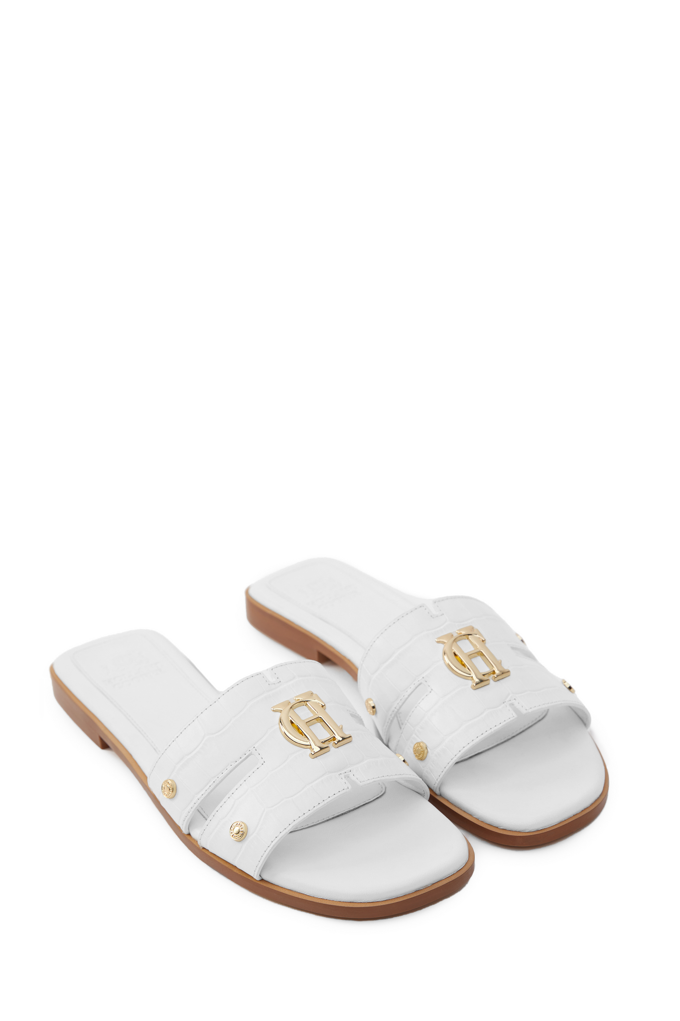 Side view of white croc embossed leather sliders with a tan leather sole and gold hardware